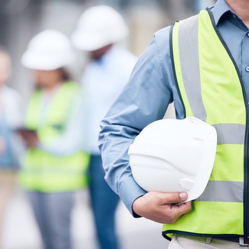 Operaio tiene in mano un casco da uso per la sicurezza sul lavoro